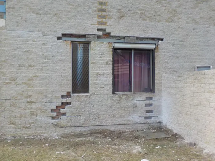Brick wall with stitched cracks around the windows